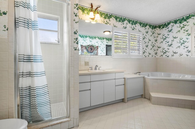 bathroom featuring vanity, independent shower and bath, tile patterned flooring, and a textured ceiling