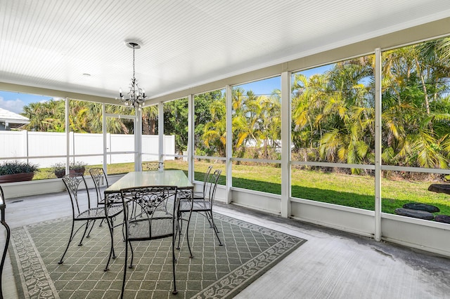 sunroom / solarium featuring an inviting chandelier