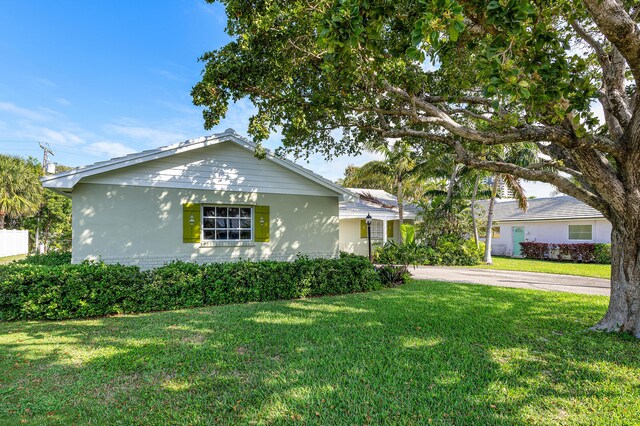 1210 Dolphin Rd, Singer Island, FL 33404 - view of front of property featuring brick siding, driveway, and a front lawn