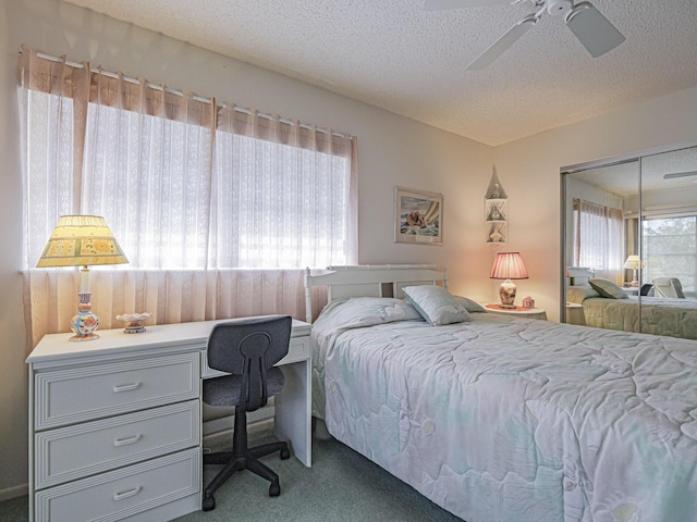 carpeted bedroom featuring ceiling fan, a closet, and a textured ceiling