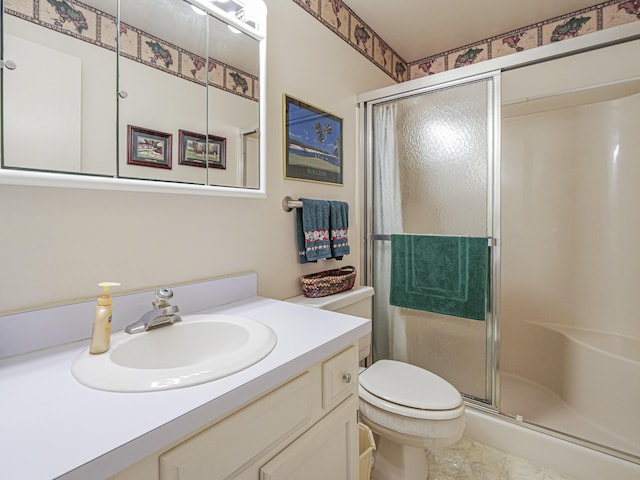 bathroom with vanity, a shower with shower door, and toilet