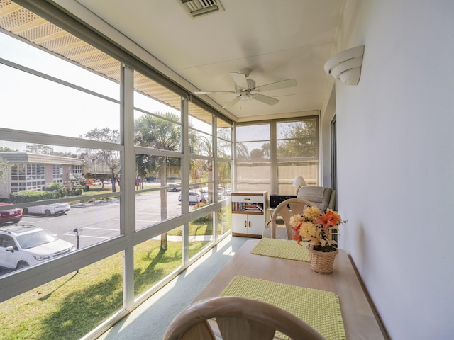 sunroom / solarium featuring plenty of natural light and ceiling fan