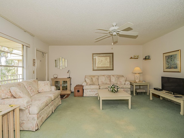 living room featuring ceiling fan, carpet floors, and a textured ceiling