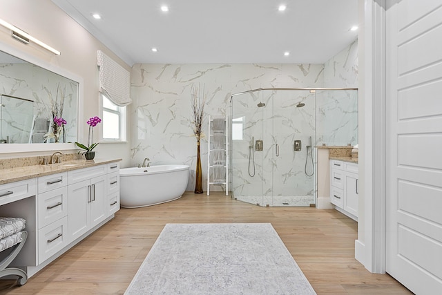 full bath with wood finished floors, a marble finish shower, and vanity