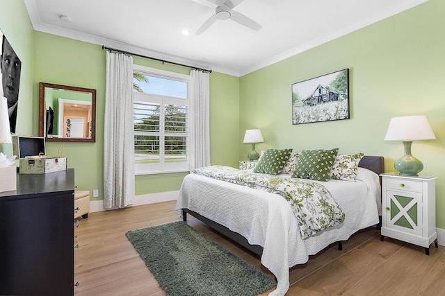 bedroom featuring baseboards, wood finished floors, a ceiling fan, and crown molding