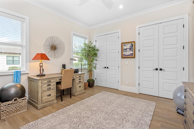 office area with baseboards, light wood finished floors, a wealth of natural light, and crown molding