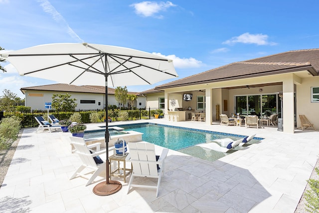 view of swimming pool with a ceiling fan, a patio, outdoor dry bar, fence, and a pool with connected hot tub