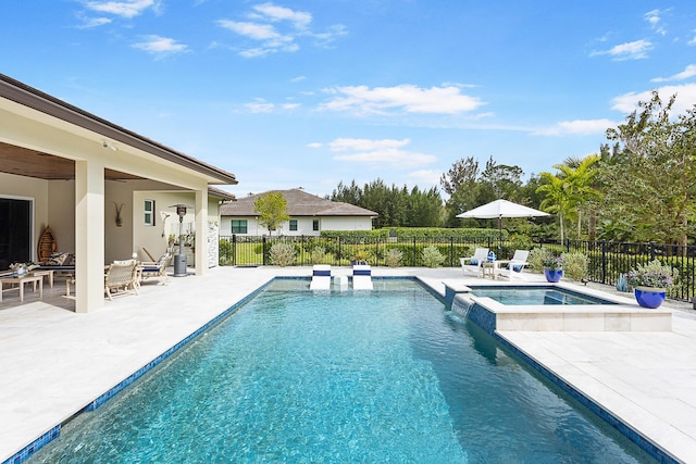 view of pool featuring a patio, fence, and a pool with connected hot tub