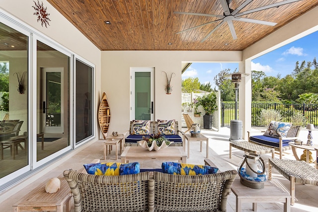 view of patio / terrace featuring a ceiling fan, fence, and an outdoor living space