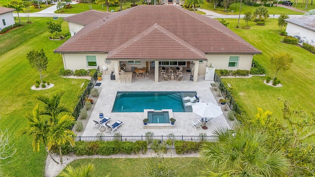 rear view of property featuring outdoor dining space, a fenced backyard, a patio, and a tiled roof