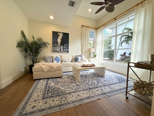 living room with dark wood-type flooring and ceiling fan