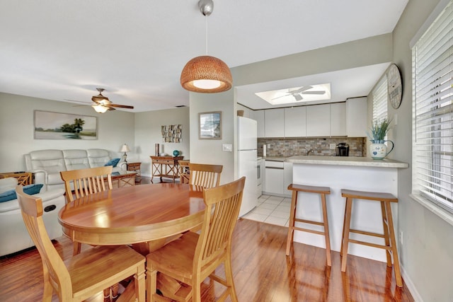 dining area with ceiling fan and light hardwood / wood-style floors