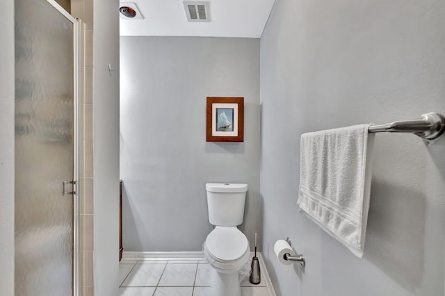 bathroom with toilet, a shower with shower door, and tile patterned flooring