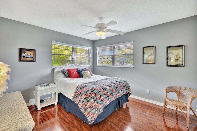 bedroom featuring ceiling fan, dark hardwood / wood-style floors, and a textured ceiling