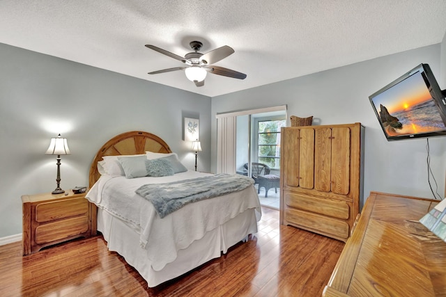 bedroom with hardwood / wood-style flooring, ceiling fan, and a textured ceiling