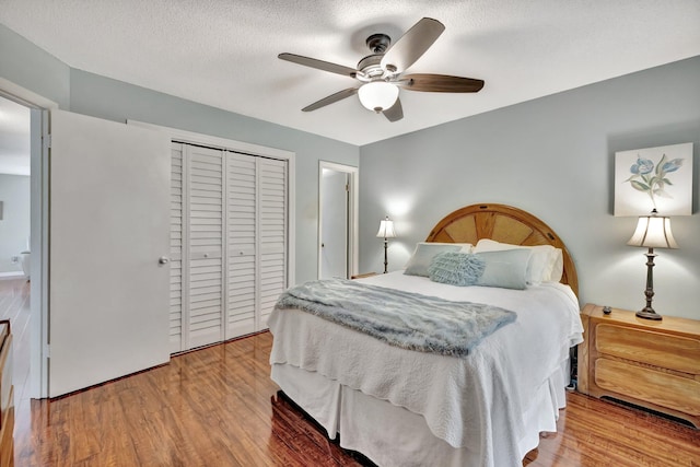 bedroom featuring ceiling fan, hardwood / wood-style floors, a textured ceiling, and a closet