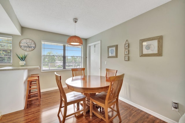 dining space featuring dark hardwood / wood-style floors and a textured ceiling