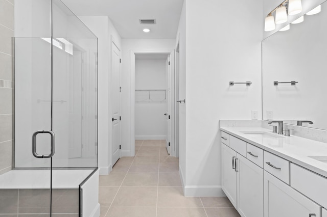 bathroom featuring a shower with door, vanity, and tile patterned floors