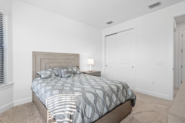 bedroom with light carpet and a closet