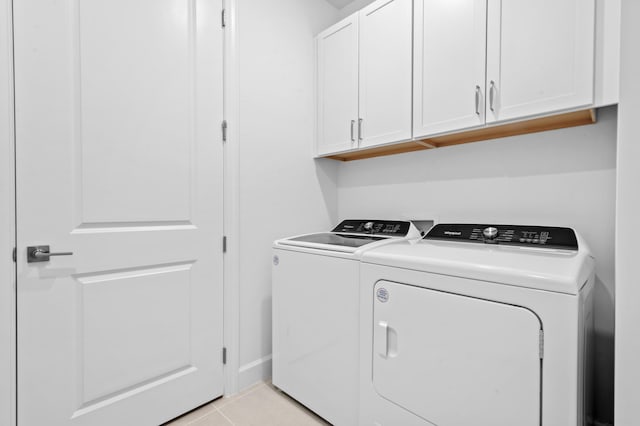 clothes washing area featuring independent washer and dryer, light tile patterned floors, and cabinets