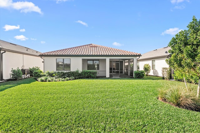 rear view of property featuring a sunroom and a yard