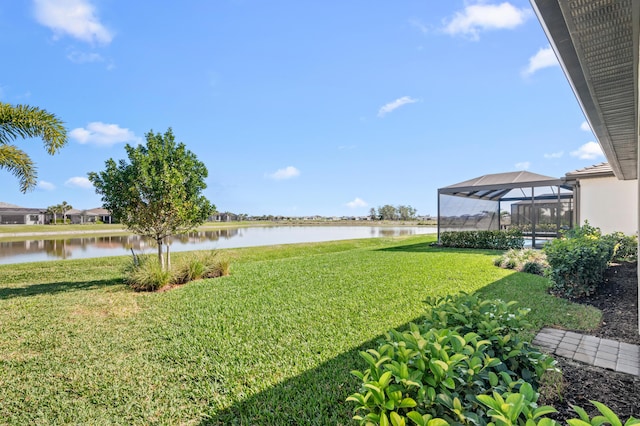 view of yard with glass enclosure and a water view