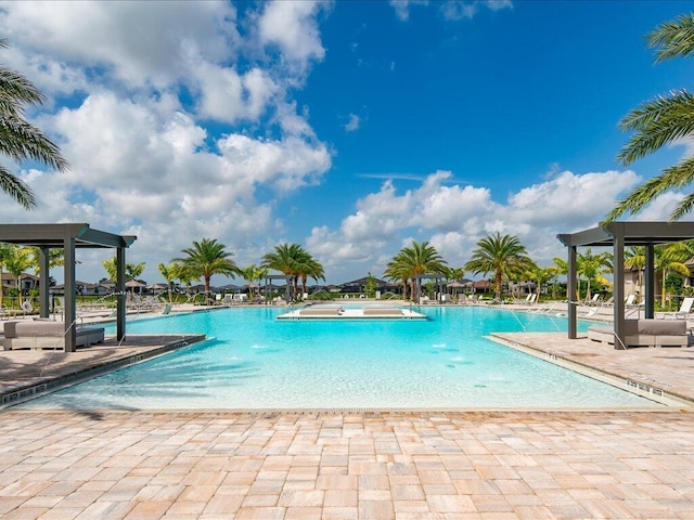 view of swimming pool with a patio, pool water feature, and a jacuzzi