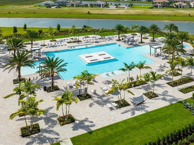 view of swimming pool with a patio area and a water view