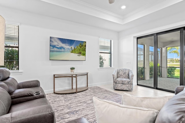 tiled living room with ornamental molding and a raised ceiling