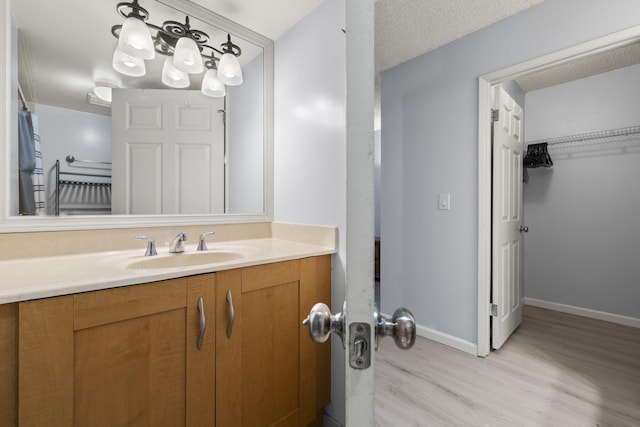 bathroom featuring hardwood / wood-style flooring, vanity, and a textured ceiling