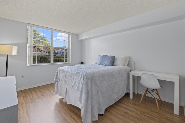 bedroom with hardwood / wood-style floors and a textured ceiling