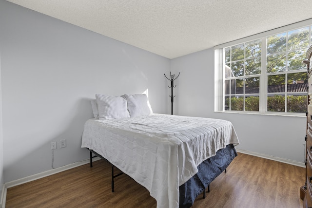 bedroom with hardwood / wood-style floors and a textured ceiling