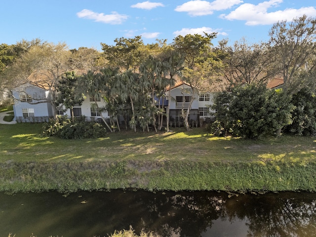 back of house featuring a water view and a yard