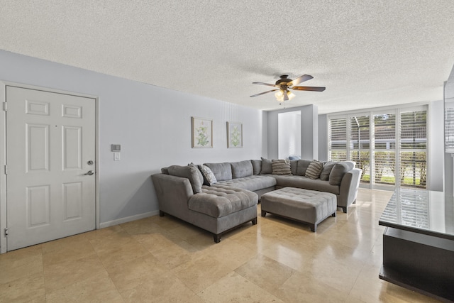 living room with ceiling fan and a textured ceiling