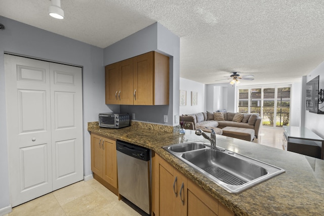 kitchen with sink, a textured ceiling, stainless steel dishwasher, and ceiling fan