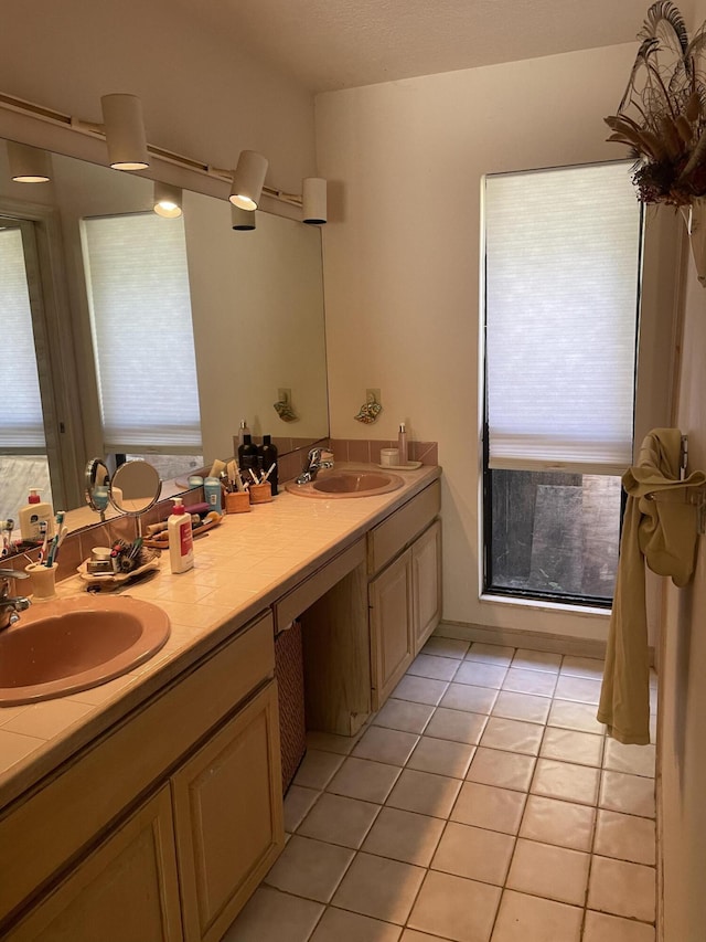 bathroom featuring a wealth of natural light, a sink, and tile patterned floors