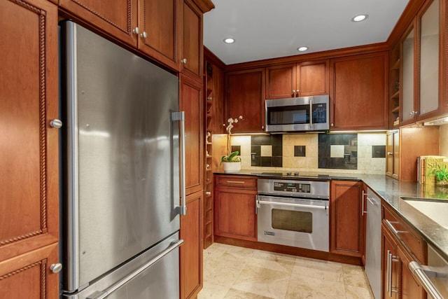 kitchen with tasteful backsplash, light stone countertops, and stainless steel appliances