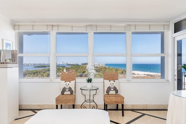 sunroom / solarium featuring a view of the beach and a water view