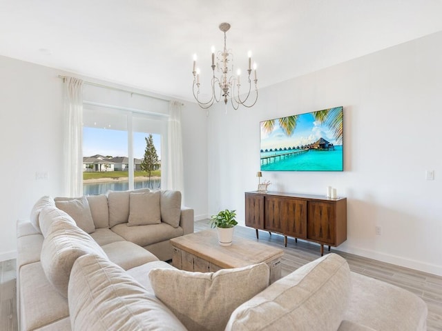 living area featuring a chandelier, baseboards, and wood finished floors