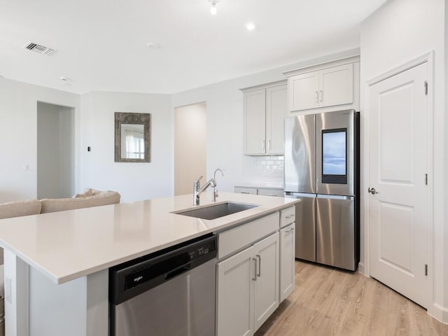 kitchen featuring stainless steel appliances, light countertops, visible vents, and a sink