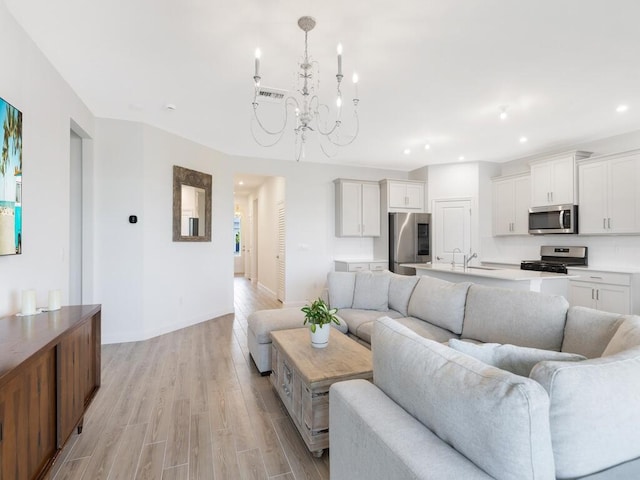 living room with a chandelier, recessed lighting, visible vents, baseboards, and light wood-type flooring