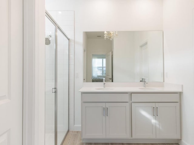 bathroom with double vanity, a stall shower, and a sink