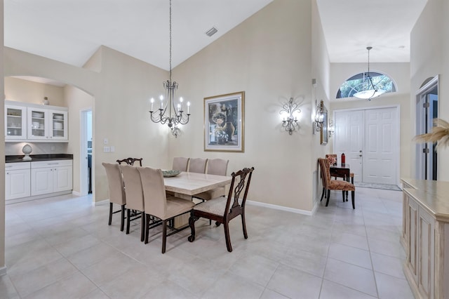 dining room featuring light tile patterned flooring, an inviting chandelier, and high vaulted ceiling