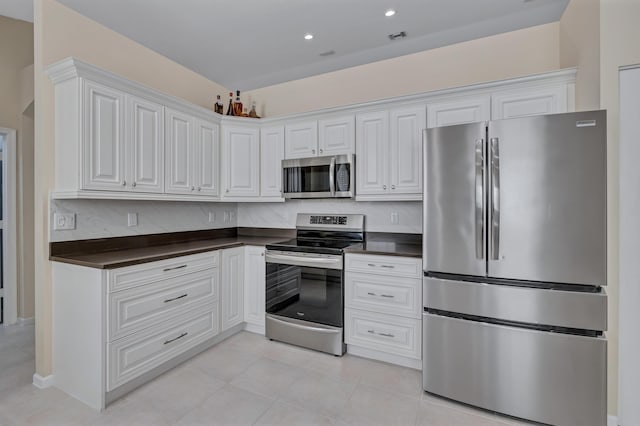 kitchen with light tile patterned flooring, appliances with stainless steel finishes, and white cabinets