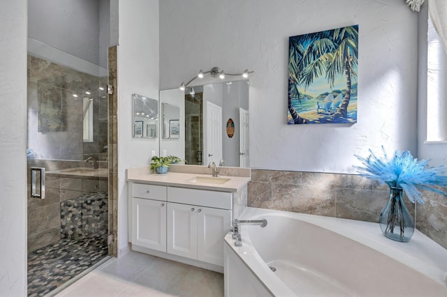 bathroom with independent shower and bath, vanity, and tile patterned floors