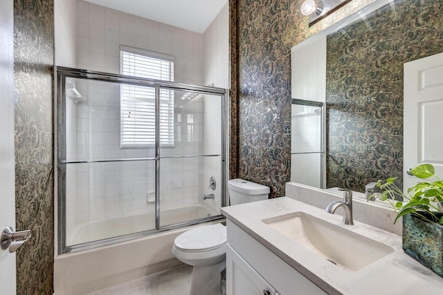 full bathroom with vanity, shower / bath combination with glass door, and toilet