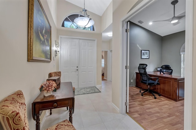 entryway featuring high vaulted ceiling and light hardwood / wood-style floors