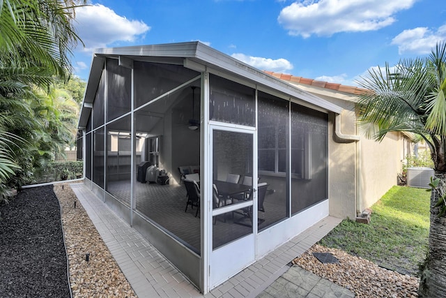 back of house featuring a sunroom and central AC