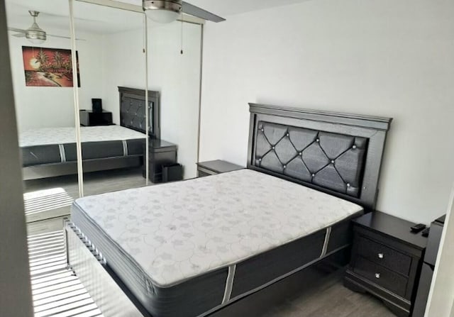 bedroom featuring dark wood-type flooring, a closet, and ceiling fan