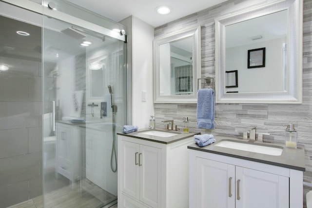 bathroom featuring an enclosed shower, vanity, and tasteful backsplash